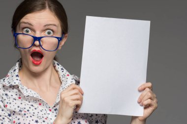 Gözlük ile güzel kız beyaz bir levha elinde tutar ve 