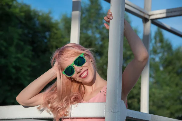 Menina bonita em óculos de sol e vestido rosa posando para um verão — Fotografia de Stock