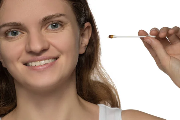 Young beautiful brunette girl cleans the ears with chopsticks wi — Stock Photo, Image