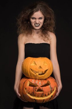 Bir cadı olarak bir makyaj ile güzel kız gülümsüyor ve bir ora tutar