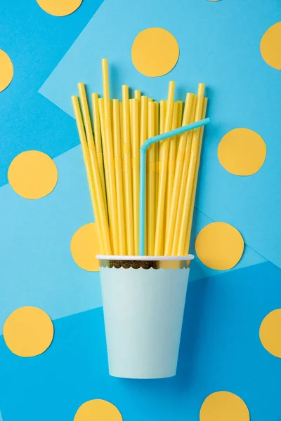 Pajitas amarillas y azules para una fiesta en vasos de papel en un bac brillante — Foto de Stock