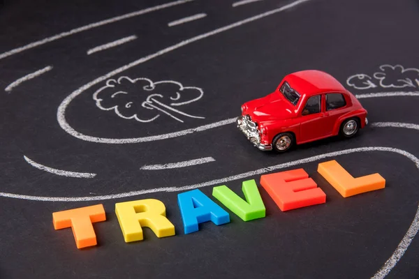 Carro de brinquedo na estrada e inscrição letras plásticas trave verão — Fotografia de Stock