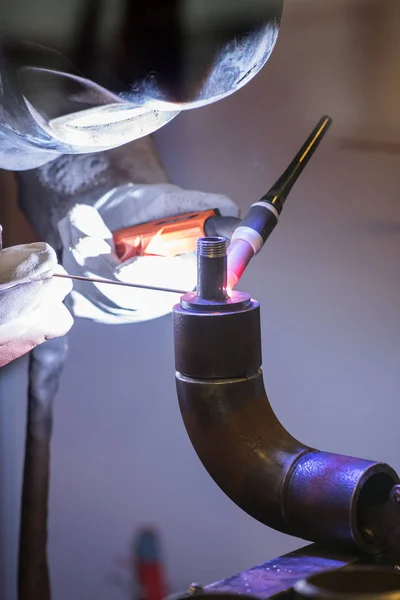 Arbetar svetsare i en mask med glas ansluter metallen genom weldin — Stockfoto