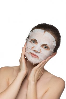 Güzel genç kadın bir yüz kozmetik maske üzerinde uygulama bir
