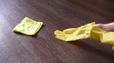 Sarı bir bez ile evin katında lastik eldiven bir kadında yıkıyor