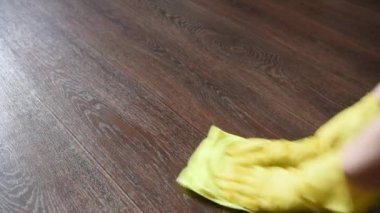 Sarı bir bez ile evin katında lastik eldiven bir kadında yıkıyor