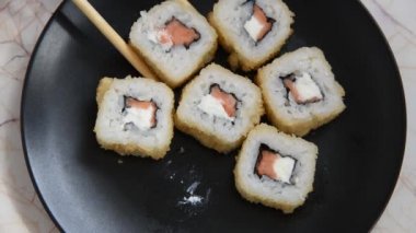 İnsanlar Japon yemek yemek. Lezzetli rulo ahşap sopa ile alınır ve soya sosuna batırılmış