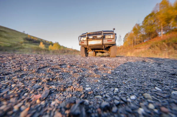 Ein Auto auf Schotter und eine Straße aus Steinen im Sommer — Stockfoto