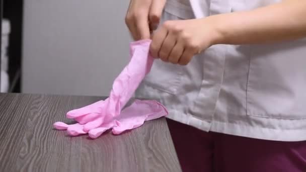 Closeup Feminino Médico Trabalhador Roupão Branco Coloca Luvas Borracha Rosa — Vídeo de Stock