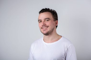 Beyaz t-shirt gülümseyen kıllar ile Yakışıklı adam