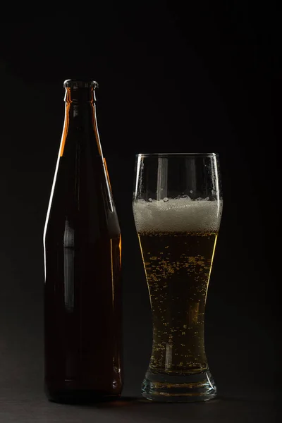 Golden beer in a bottle and in a glass and snack nuts, squid and — Stock Photo, Image