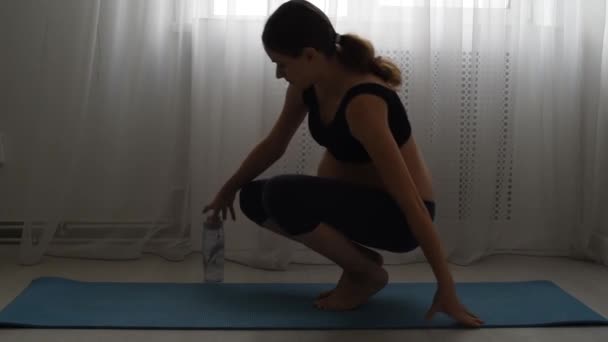 漂亮的年轻孕妇在家里的地毯上练习瑜伽 体操在垫子上 有一个不好的伸展的女孩 — 图库视频影像