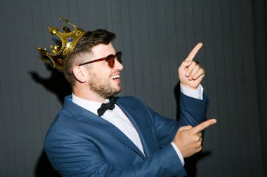 Young man in crown pointing up