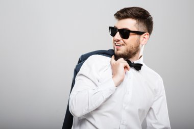Young man holding jacket and looking aside