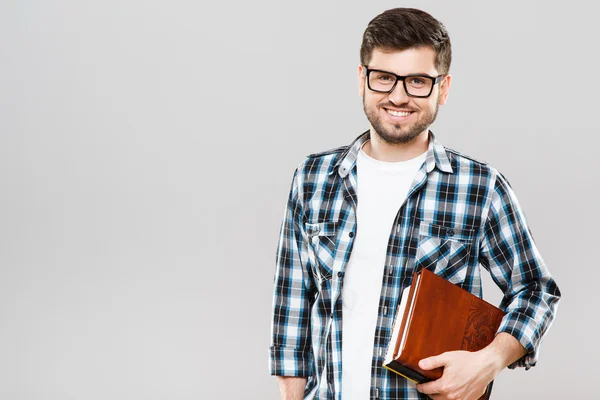 Junger Mann hält Bücher mit einer Hand — Stockfoto