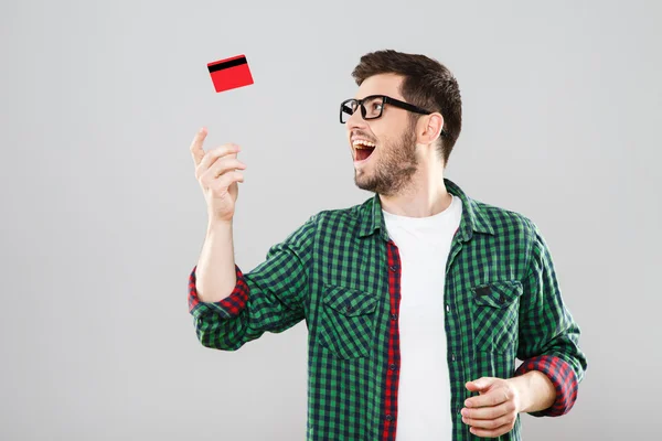 Man throwing up red credit card — Stock Photo, Image