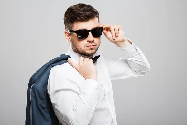 Young man in sunglasses holding jacket — Stock Fotó