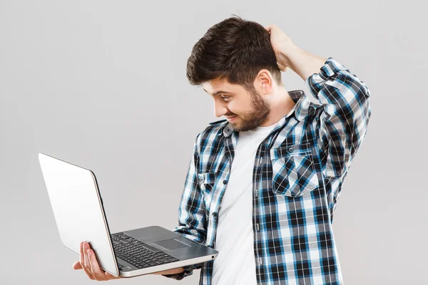 Jonge man kijkend naar laptop — Stockfoto