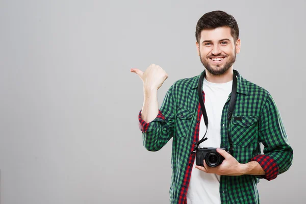 Hombre sosteniendo la cámara y señalando a un lado —  Fotos de Stock