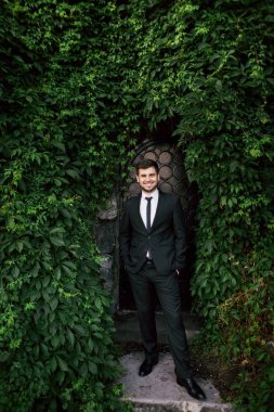 Damat yeşil yaprakları altında gülümseyen