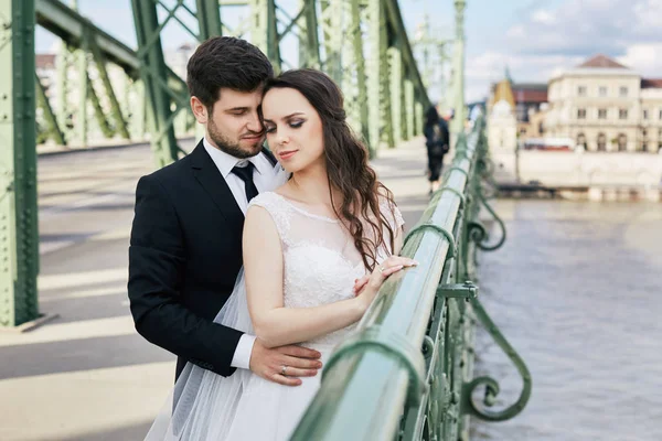 Happy couple standing on old bridge