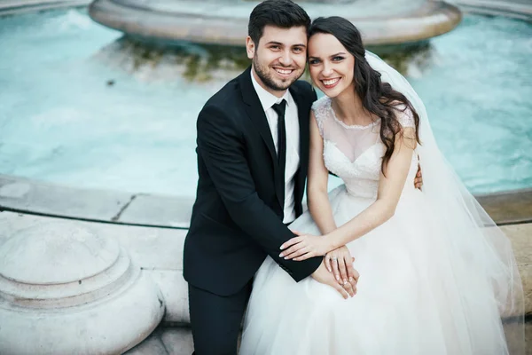 美丽的夫妇坐在喷泉旁边 — 图库照片