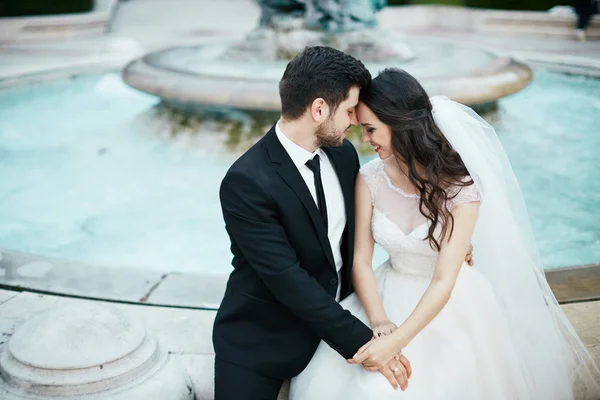 Красива пара сидить біля фонтану — стокове фото