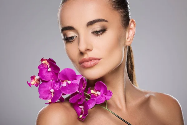 Flicka med lila orkidé — Stockfoto