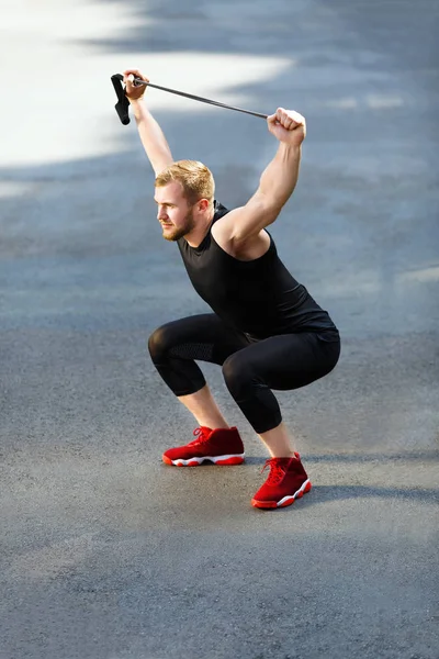 Man die gehurkt met expander — Stockfoto