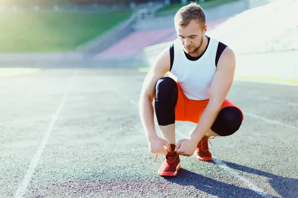 Deportista agachado en zapatillas de deporte — Foto de Stock