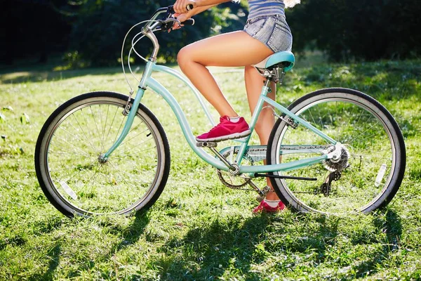 Piernas de mujer joven con bicicleta — Foto de Stock