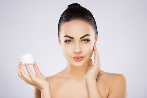 девушка держит крем
