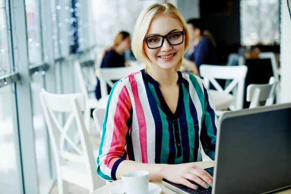 Chica sentada en la cafetería con portátil — Foto de Stock