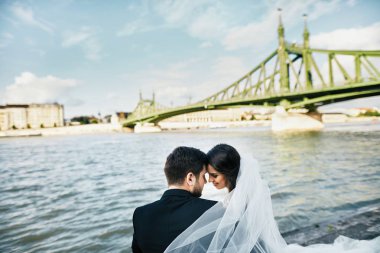 Gelin ve damat birlikte nehir kenarında oturan