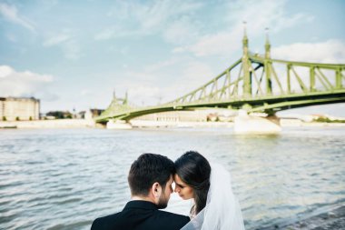 Gelin ve damat birlikte nehir kenarında oturan