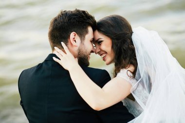 Gelin ve damat birlikte nehir kenarında oturan