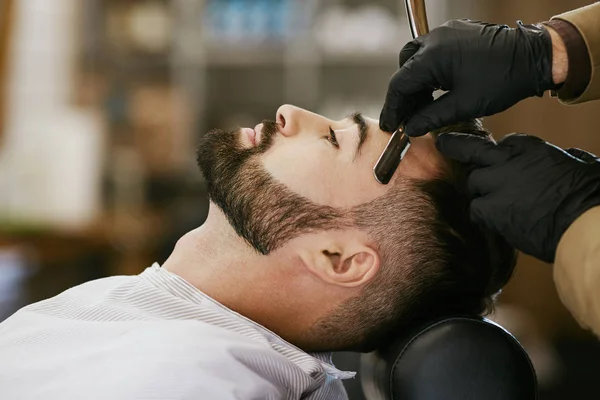 Парикмахер делает бороду форму для человека — стоковое фото