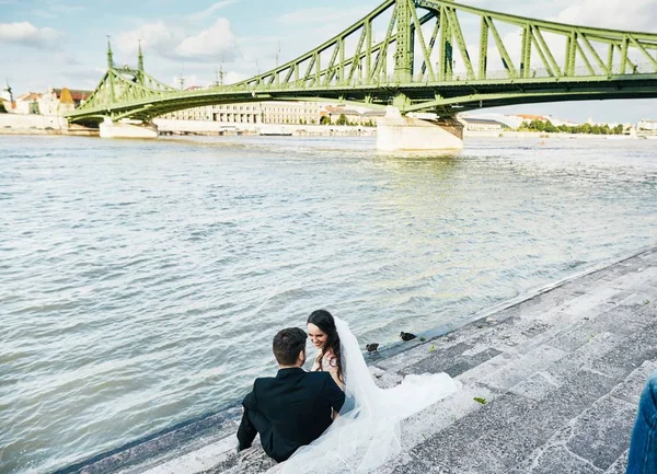 Наречена і наречений сидять разом біля річки — стокове фото