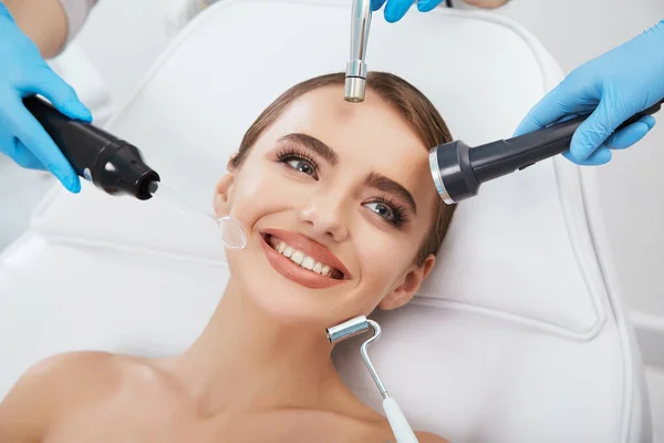 Different cosmetological instruments around face — Stock Photo, Image