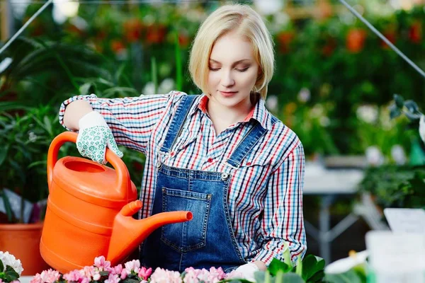 Jovem mulher regando flores — Fotografia de Stock