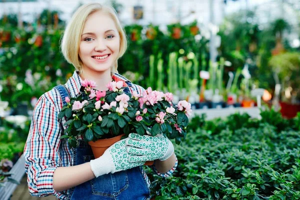 Mujer joven sosteniendo macetas con plantas — Foto de Stock