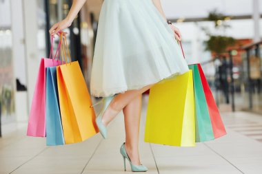Güzel kızın bacakları ile alışveriş torbaları