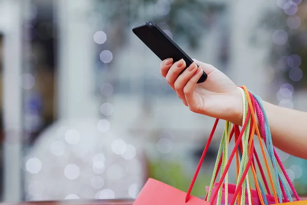 Mano sosteniendo coloridas bolsas de compras —  Fotos de Stock