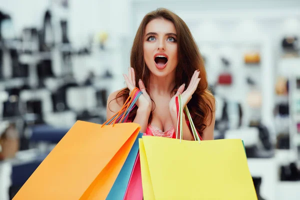 Mujer joven de pie con bolsas de compras —  Fotos de Stock