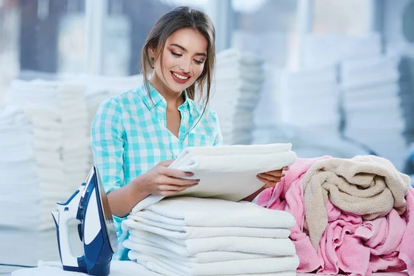 Mujer apilando ropa blanca en un montón — Foto de Stock