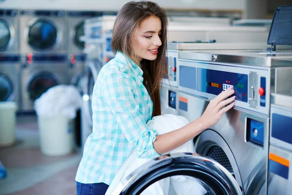 Jeune femme activant la machine à laver — Photo