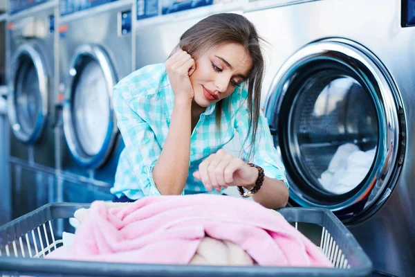 Mujer esperando cerca de lavadoras — Foto de Stock