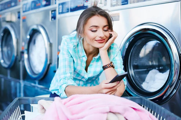 Mujer usando aplicación para lavar ropa — Foto de Stock