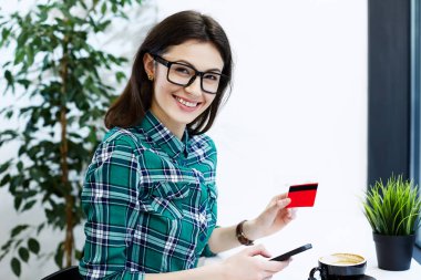 kredi kartı ve telefon tutan kadın