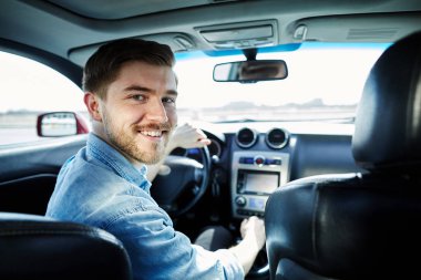 Attractive man sitting in automobile  clipart